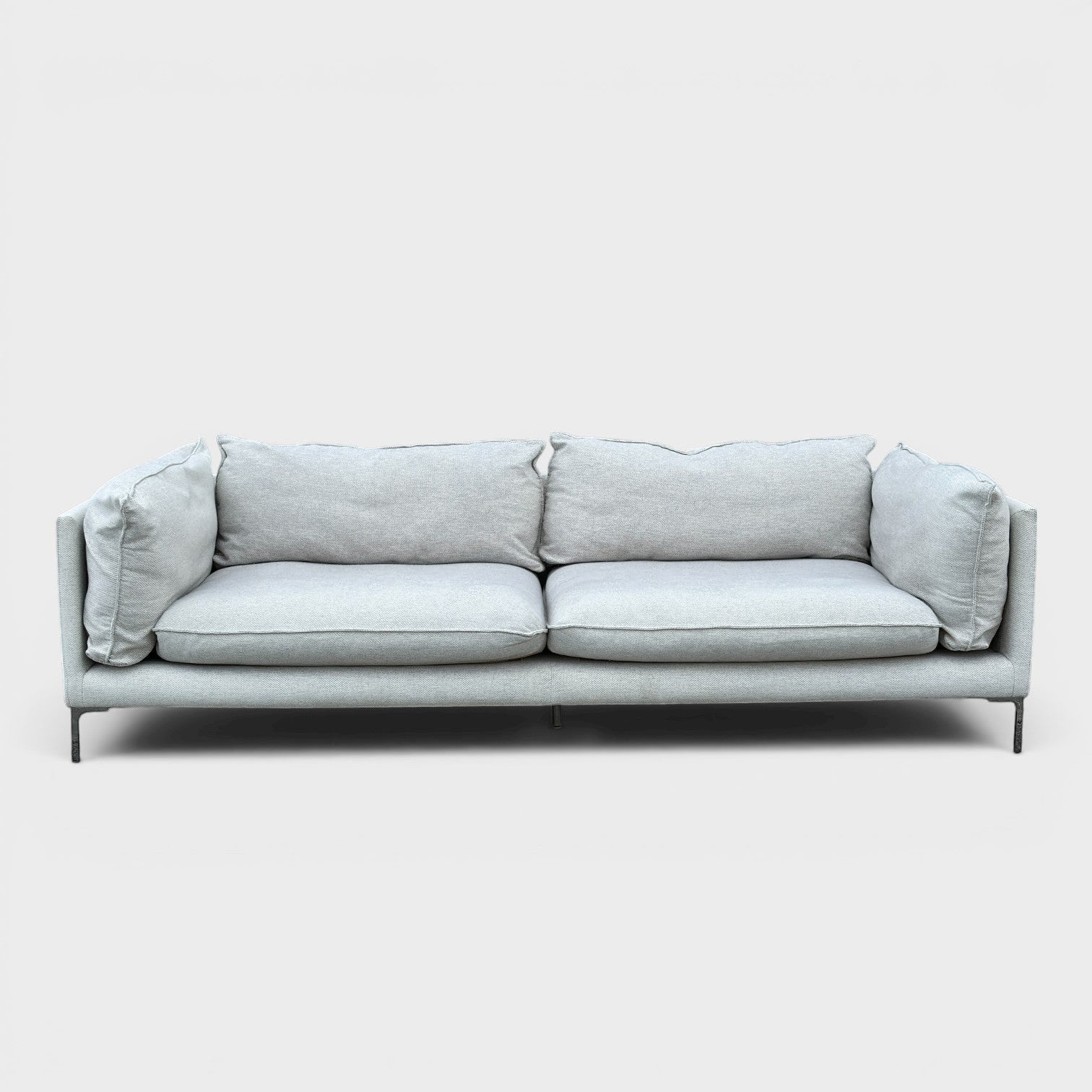 RehomedHere light grey three-seater sofa with plush cushions and slim stainless steel legs, modern design.